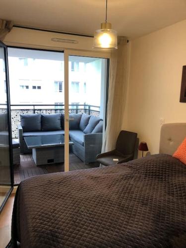 - une chambre avec un lit bleu et un canapé dans l'établissement Appartement Neuf de 40 M2 à Issy-Les-Mx / Paris 15, à Issy-les-Moulineaux