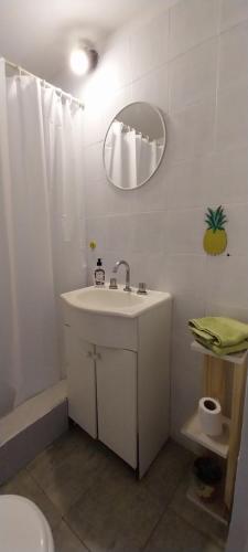 ein weißes Badezimmer mit einem Waschbecken und einem Spiegel in der Unterkunft La Casita de Hotei in Mar del Plata