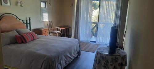 1 dormitorio con 1 cama y TV. en Amanecer de Costa del Sol, en Lago Rapel