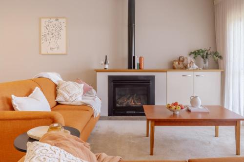 uma sala de estar com um sofá e uma lareira em Hermitage Lodge em Pokolbin