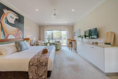 a hotel room with a large bed and a kitchen at Hermitage Lodge in Pokolbin