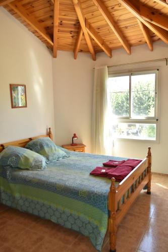 Hostal Madryn في بويرتو مادرين: غرفة نوم بسرير ونافذة كبيرة