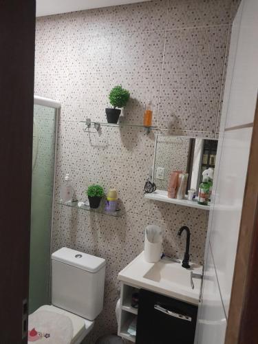 a bathroom with a toilet and a sink and a mirror at Residencial in Salvador