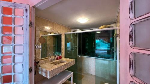 een badkamer met een wastafel en een spiegel bij Casa com vista a praia da Barra do Sahy in Barra do Sahy