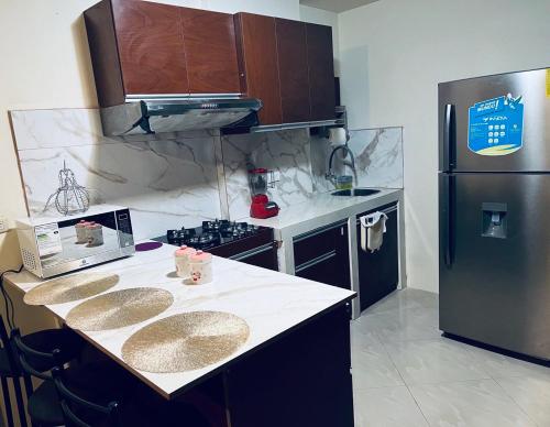 Il comprend une cuisine équipée d'un réfrigérateur noir et d'un comptoir. dans l'établissement Departamento en urbanización privada, à Machala