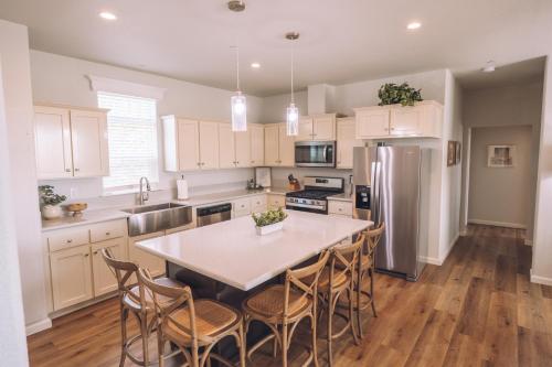a kitchen with a table with chairs and a refrigerator at Ranch House at Galway Downs in Temecula
