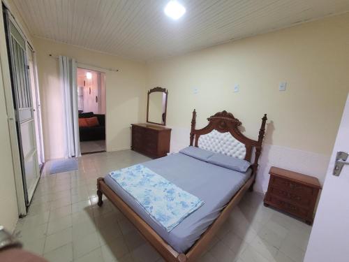 Schlafzimmer mit einem Bett, einer Kommode und einem Spiegel in der Unterkunft Suíte 2 com sala in Lages
