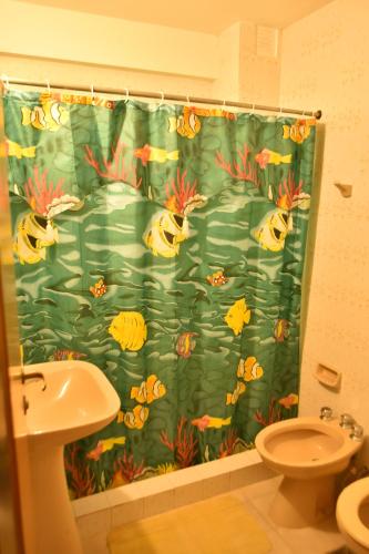 a bathroom with a shower curtain with fish on it at Complejo Turístico Hostal Madryn in Puerto Madryn