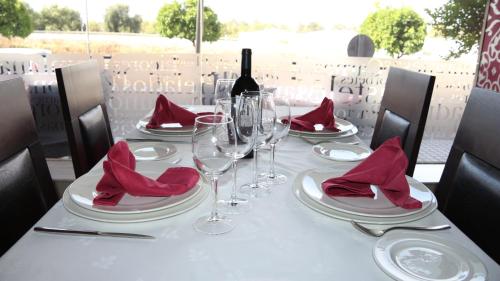 a table with red napkins and a bottle of wine at Hotel Macami in El Carpio