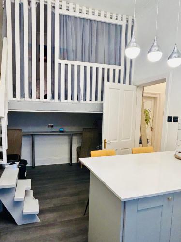 a kitchen with a white counter and a table at Glasgow Center/West End Apartment in Glasgow