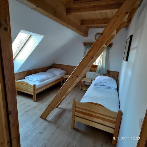a attic room with two beds and two windows at Chalet Kočí in Kořenov