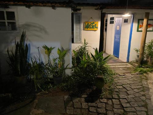 a house with a blue door and some plants at Casa Lee Hostel in Paraty