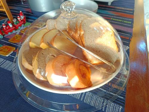 a bowl of bread and apples on a glass plate at Tonpho homestay Lampangต้นโพธิ์โฮมสเตย์ in Ban Mai