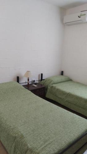 um quarto com 2 camas e uma mesa com um candeeiro em CasaTribuno em Salta
