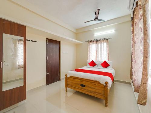 a bedroom with a bed with red pillows at OYO Flagship Srinivasa Residency in Chennai