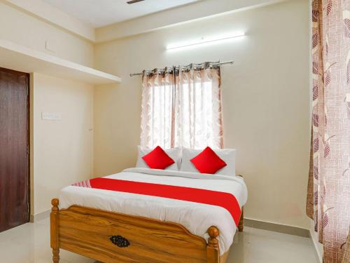 a bedroom with a large bed with red pillows at OYO Flagship Srinivasa Residency in Chennai