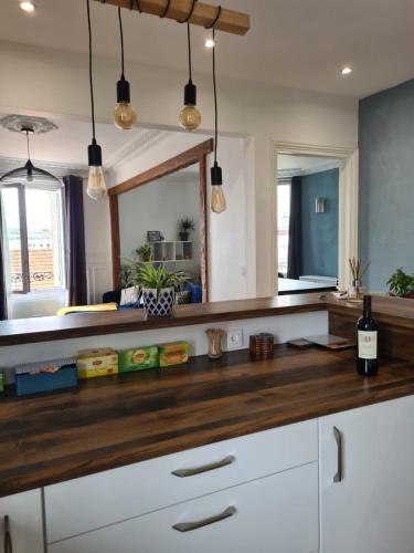 - une cuisine avec un comptoir et un miroir dans l'établissement Magnifique appartement La Défense 10min Pte Maillot, à Courbevoie