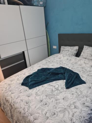 un lit avec une chemise bleue sur le dessus dans l'établissement Magnifique appartement La Défense 10min Pte Maillot, à Courbevoie