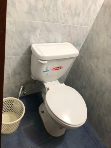 - białą toaletę w łazience z koszem w obiekcie HOSPEDAJE las PRIMICIAS RIOBAMBA 104 w mieście Riobamba
