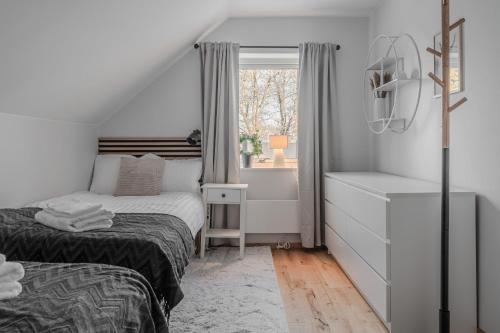 ein kleines Schlafzimmer mit einem Bett und einem Fenster in der Unterkunft Guestly Homes - 4BR Cozy Corporate Villa in Piteå