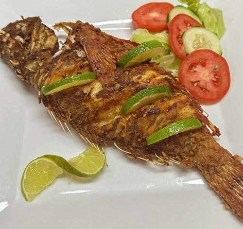 um prato de comida com peixe e uma salada em HOTEL LUXURY VIP em Punta Rucia
