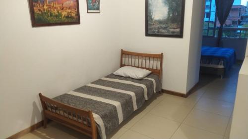 a small bed sitting in a room with at Apartamento pequeño, acogedor, 1 habitación, vista a zonas verdes, English in Calarcá