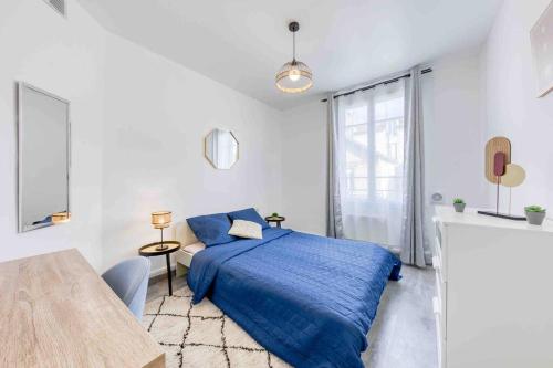 - une chambre avec un lit bleu et une table dans l'établissement Appartement Cosy I Proche de la Porte de Versailles Paris, à Malakoff