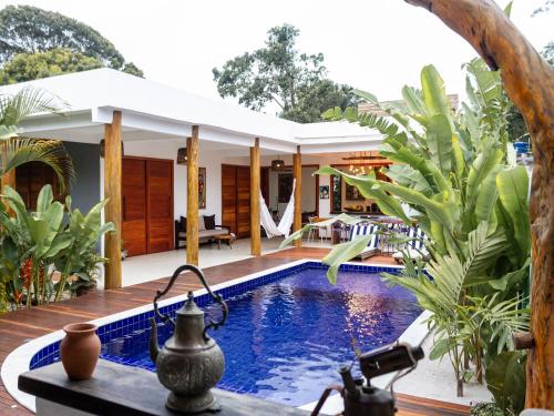 una piscina en un complejo con una mesa y una cámara en CASA SIMONI Trancoso, en Trancoso