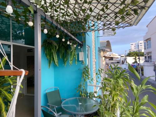 un patio con una pared azul, una mesa y sillas en Hostal Casa Latina, en Manta