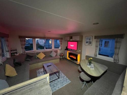 sala de estar con sofá y mesa en Primrose valley - Primrose Field 46 holiday home, en Filey
