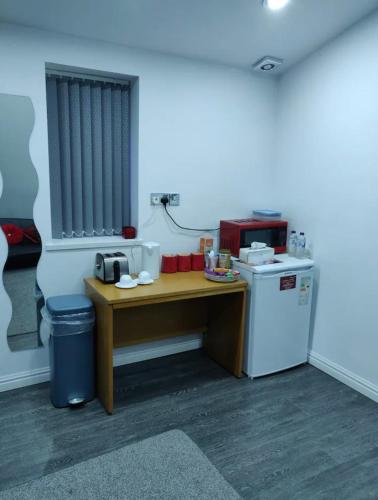 a kitchen with a table and a microwave and a refrigerator at Rooms for rent in Solihull in Solihull