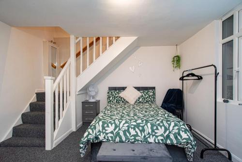 a bedroom with a bed with a green bedspread at Watford Central Serviced Apartments in Watford