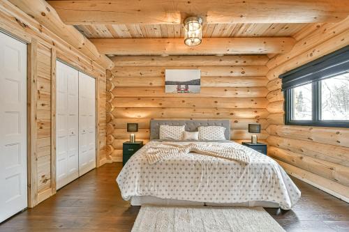 1 dormitorio con 1 cama en una pared de madera en Le Chalet Enchanté en Saint-Donat-de-Montcalm