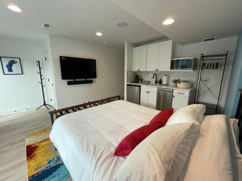 um quarto com uma grande cama branca com almofadas vermelhas em Private, cozy, suite by Mile High Stadium and Downtown Denver! em Denver