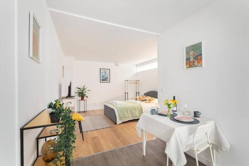 a white room with a bed and a table at Studio Cosy Paris/CDG/Expo/Stade in Aulnay-sous-Bois