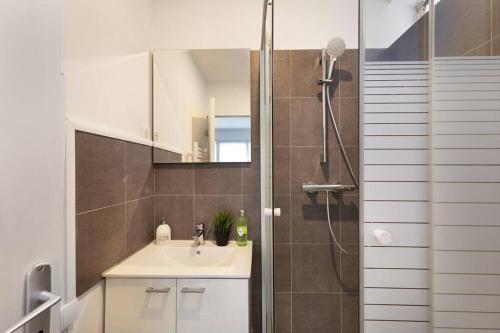a bathroom with a sink and a shower with a mirror at Studio Cosy Paris/CDG/Expo/Stade in Aulnay-sous-Bois