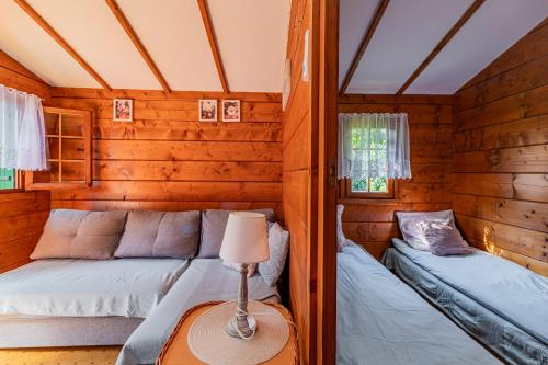 a room with two beds in a log cabin at Domki Letniskowe Wiktoria in Dąbki