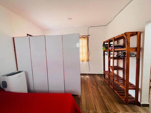 um quarto com armários brancos e uma escada ao lado de uma cama em Mini house con sol y luz em Buenos Aires