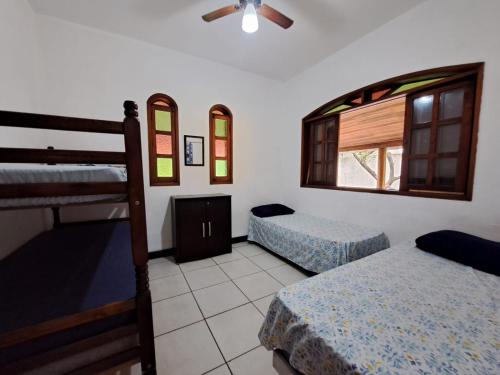a bedroom with two bunk beds and a window at Casa Daslis Espaçosa e Bem Localizada in São Sebastião