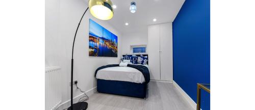 Comfortable and Stylish 1 BR flat - Sleeps 2 في لندن: غرفة نوم صغيرة بجدار ازرق وابيض