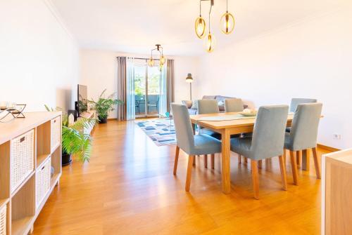Un comedor y una sala de estar con mesa y sillas. en Serene Haven Retreat - Madeira Island, en Caniço