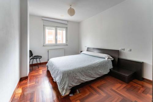 1 dormitorio con 1 cama y suelo de madera en Good Stay Lugo Apartment, en Lugo