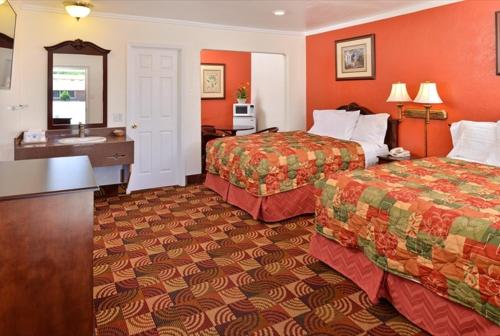 a hotel room with two beds and a sink at Americas Best Value Inn & Suites Klamath Falls in Klamath Falls