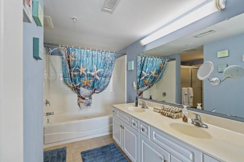 a bathroom with two sinks and a tub and a mirror at Crescent Beauty in Myrtle Beach