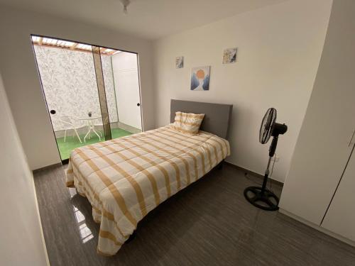Habitación pequeña con cama y ventana en Hermoso Departamento en urb. Ballestas con seguridad privada, en Pisco