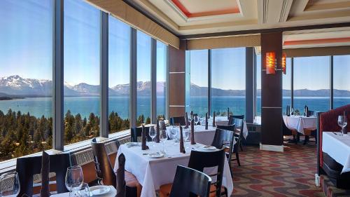 a restaurant with tables and chairs and large windows at Caesars Republic Lake Tahoe in Stateline