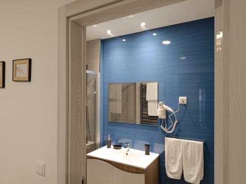 Łazienka z umywalką i niebieską ścianą w obiekcie Garden House Fundão - Suíte 202 com varanda w mieście Fundão