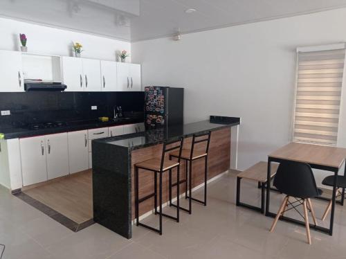 a kitchen with a black counter and a table and chairs at Quinta Villateo in Villavicencio