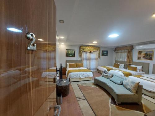 a room with three beds and a couch at Resort altayar Villa altayar 2- Aqua Park in Sidi Kirayr