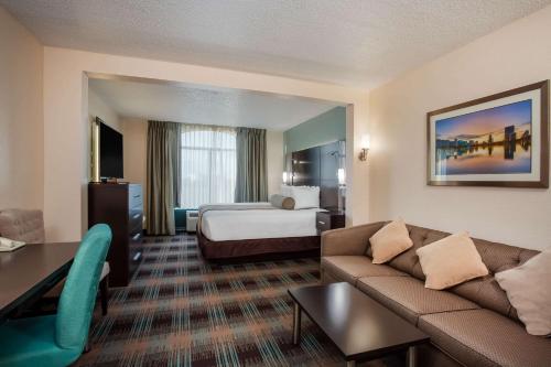 a hotel room with a couch and a bed at Wingate By Wyndham - Orlando International Airport- Free Hot Breakfast in Orlando